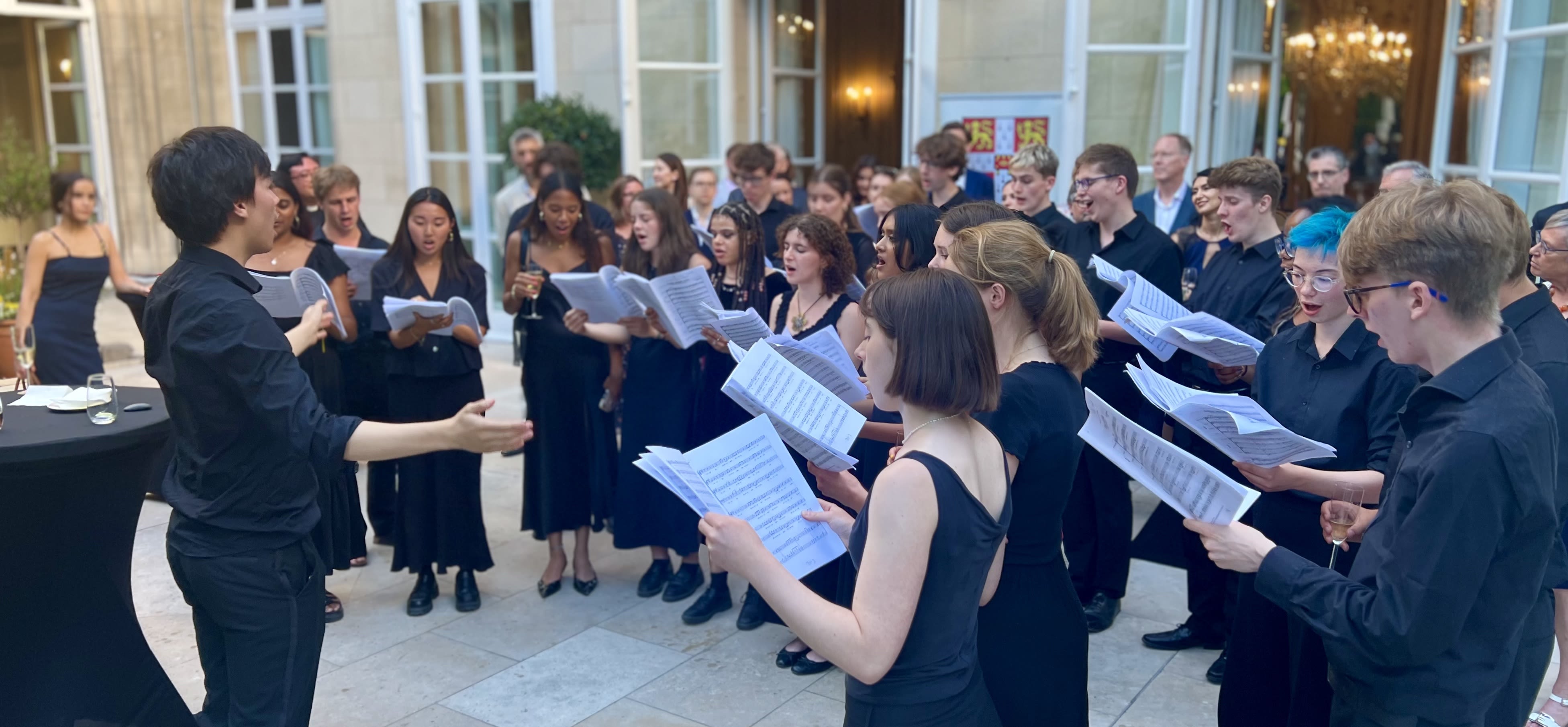 Smartly dressed students sing in formal residence