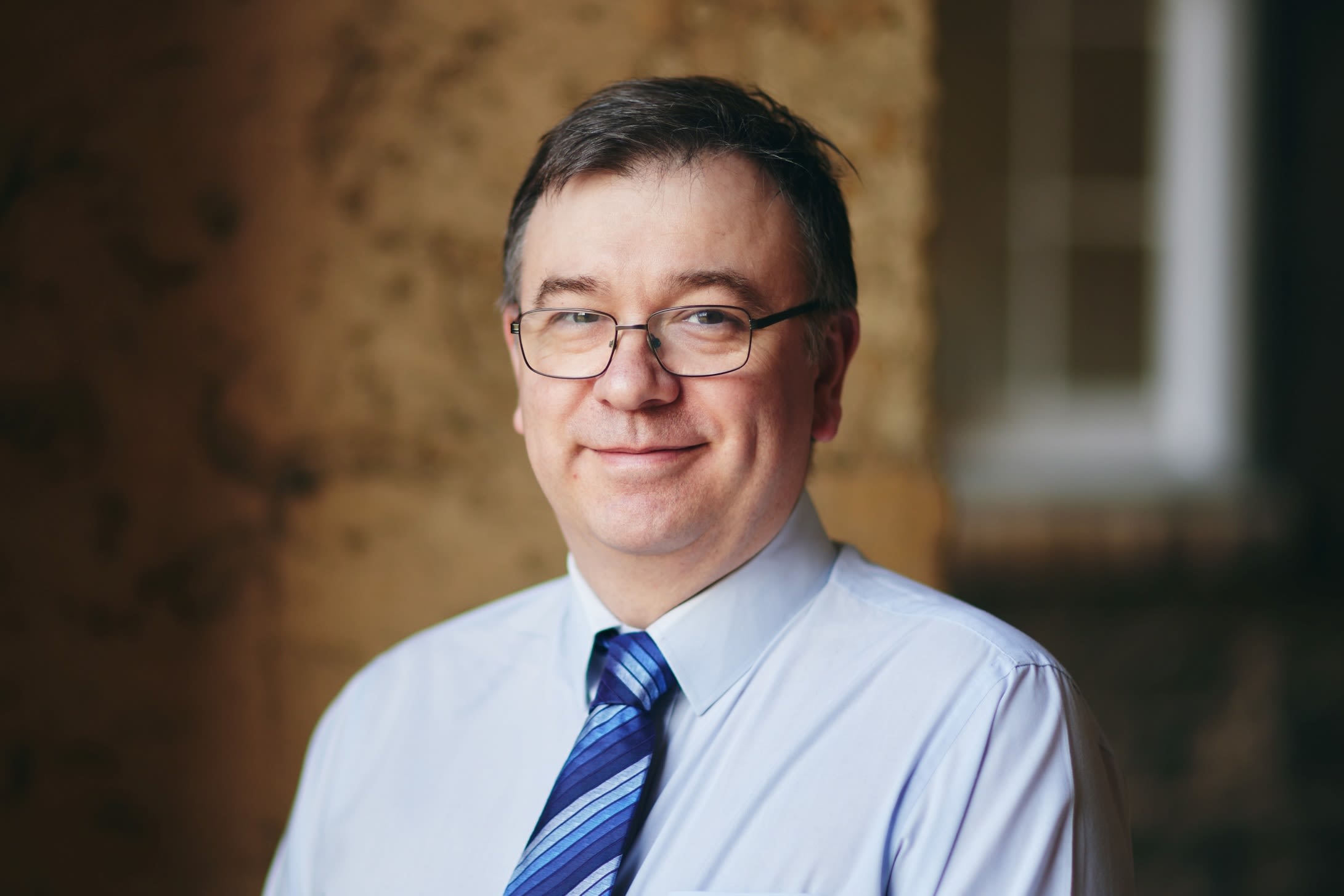 Man in blue tie smiles at camera