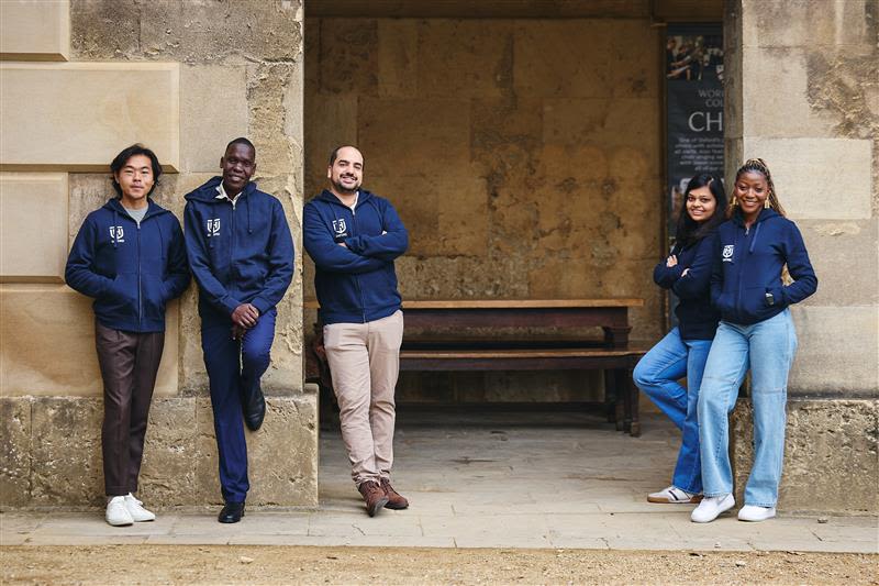 Five student scholars smile at camera