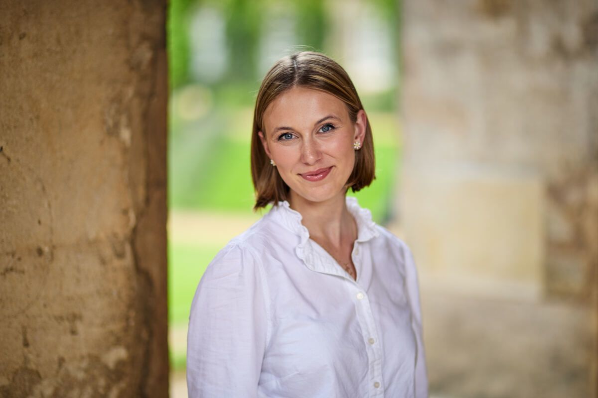 Woman in white shirt smiles at camera