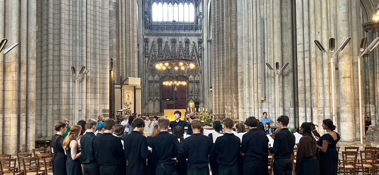 Student choir dressed in black sing in Gothic cathedral
