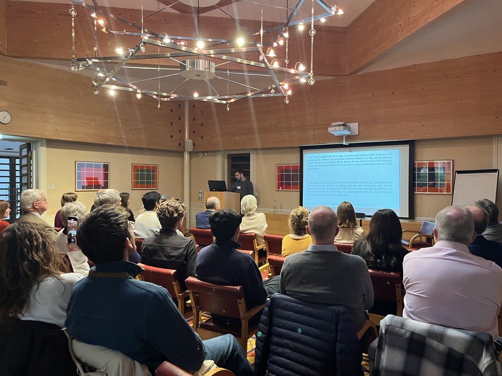 A graduate speaker addresses an audience in College