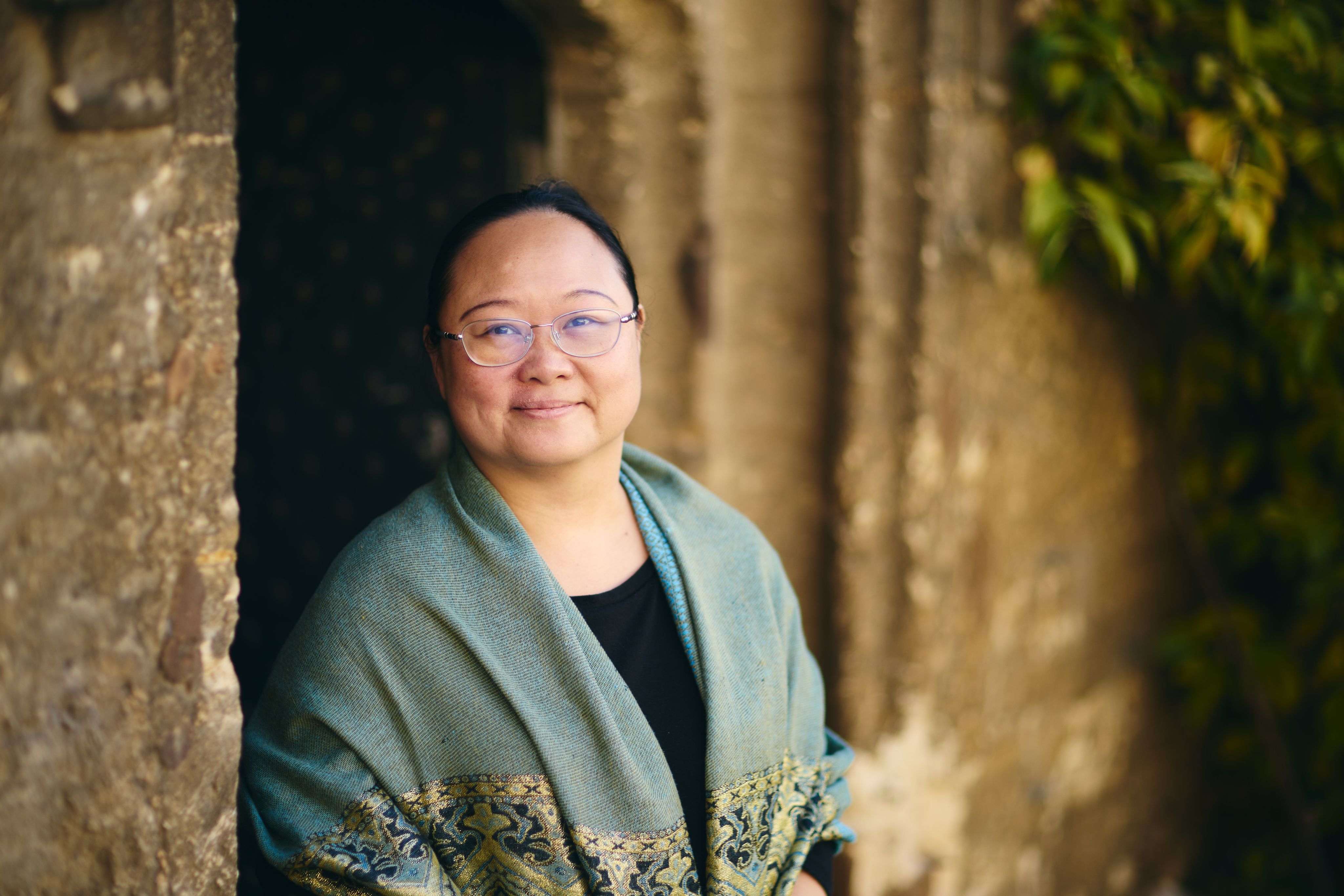 Woman in green shawl smiles at camera