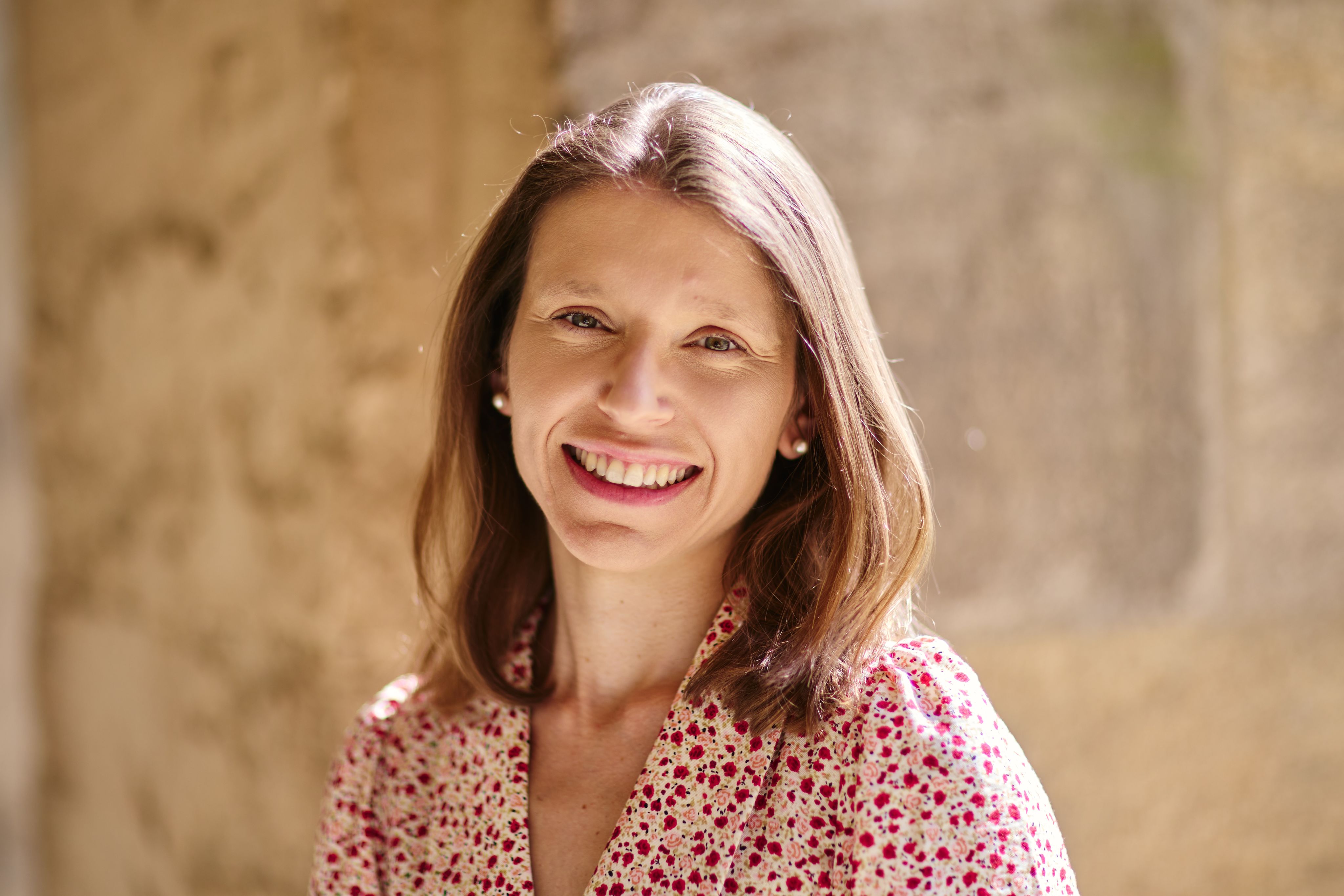 Woman in floral dress smiles at camera