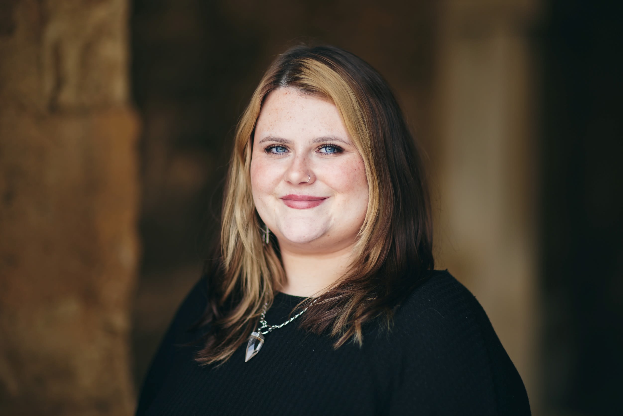 Woman in black top smiles at camera